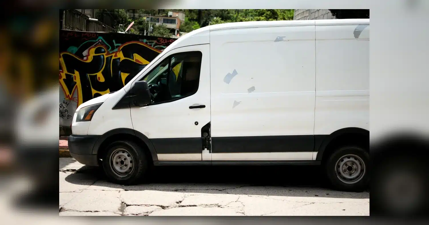 Van Decals Fonts — A white delivery van parked beside a colorful graffiti wall in an urban area.