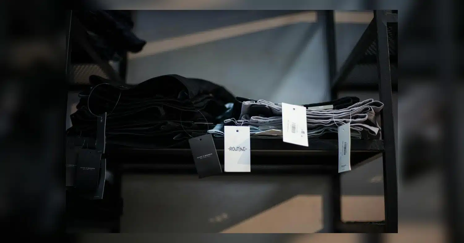 Custom Employee Uniform — Stylish garments neatly folded on shelves in a modern boutique shop setting.