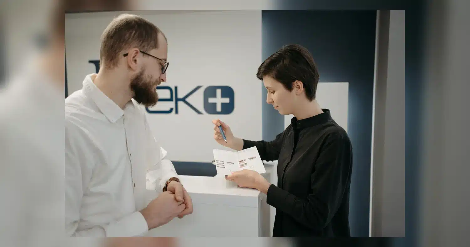 local printing near humber college — Customer discussing information sheet with receptionist in clinic.