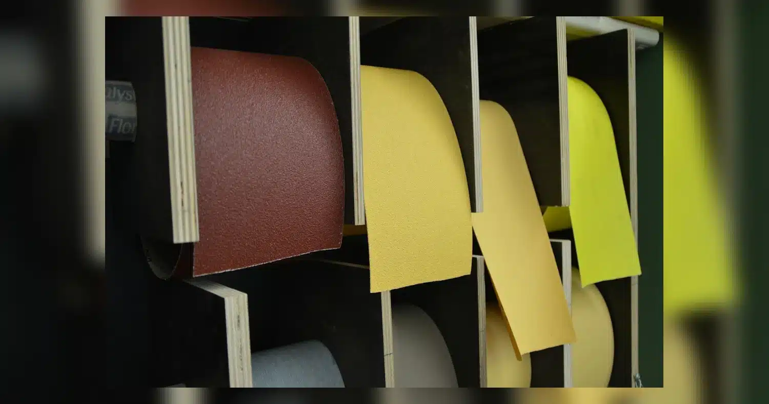 cast vs calendered vinyl , Close-up of colorful sandpaper rolls in an organized storage setup, showcasing different textures.