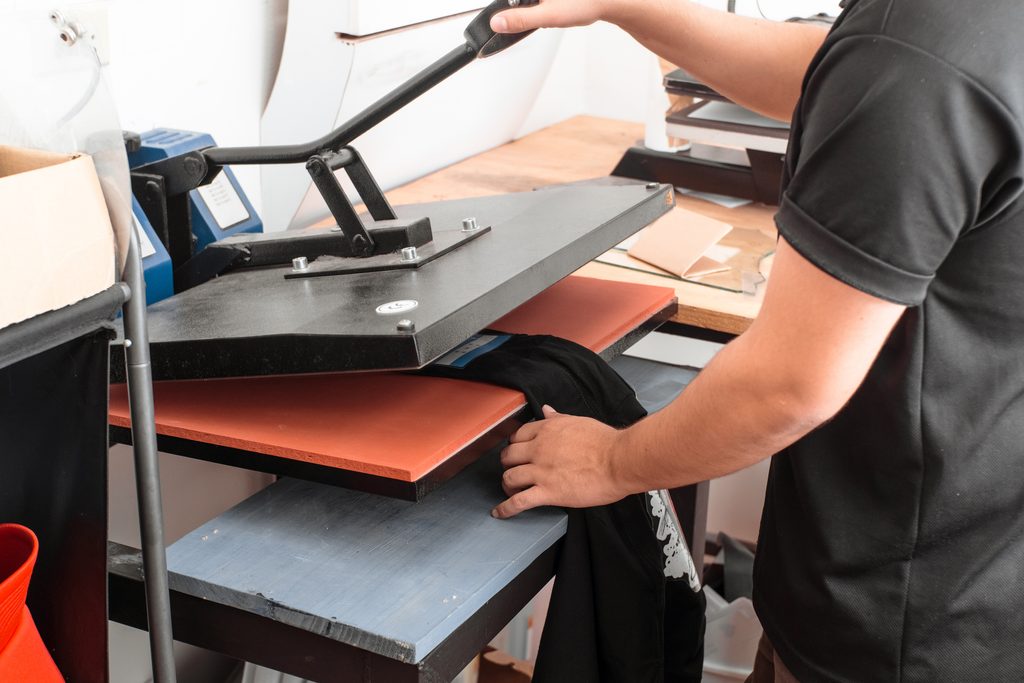 a unrecognizable person working on a iron sublimation. printing concept and graphic design.