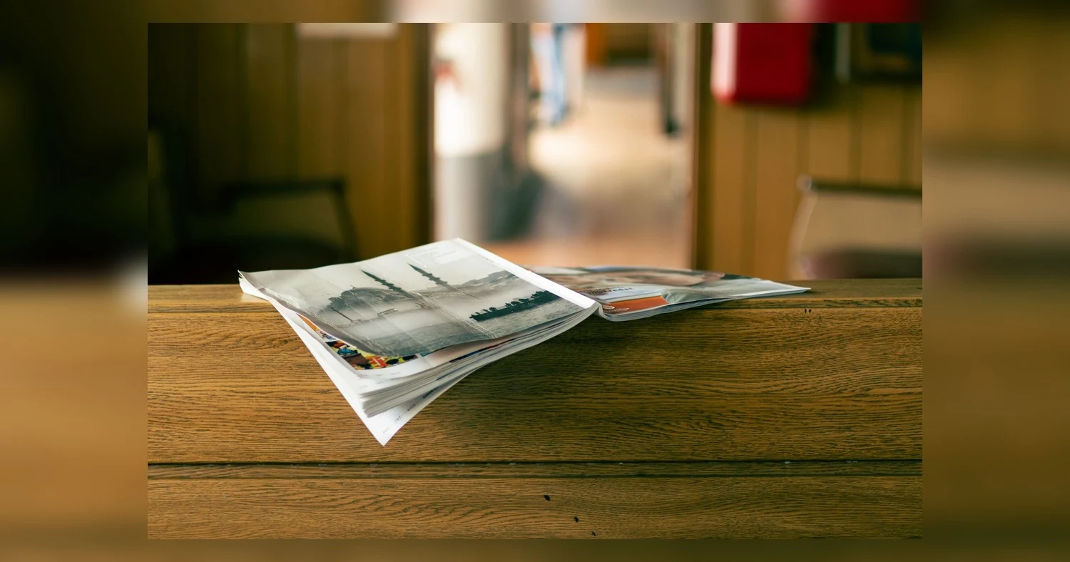booklet printing Toronto — Stack of magazines on a wooden table in a cozy indoor environment.